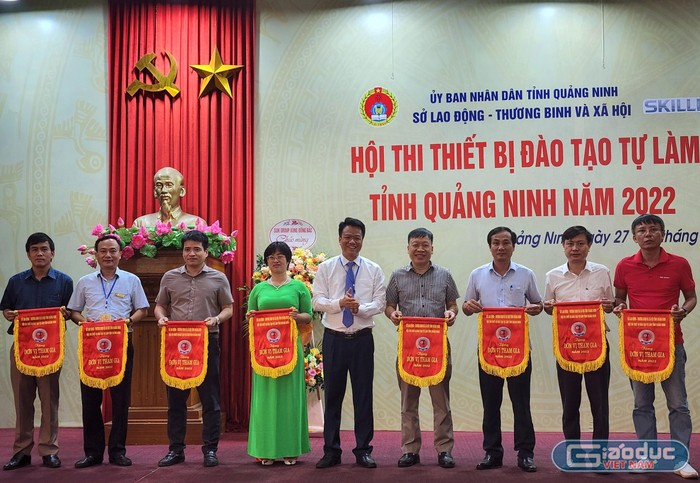 Ông Vũ Quang Trực - Phó Giám đốc Sở Lao động - Thương binh và Xã hội Quảng Ninh tặng cờ lưu niệm cho các đơn vị tham gia hội thi. (Ảnh: Phạm Linh)