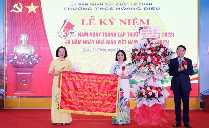 Ông Lê Khắc Nam - Phó Chủ tịch Uỷ ban nhân dân thành phố trao tặng nhà trường bức trướng của Uỷ ban nhân dân thành phố (Ảnh: Phạm Linh)