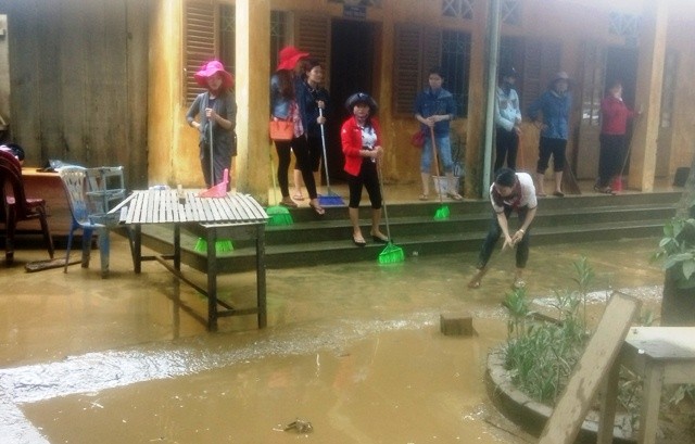 Các thầy cô giáo trường tiểu học Tân Hóa dọn dẹp sau lũ.