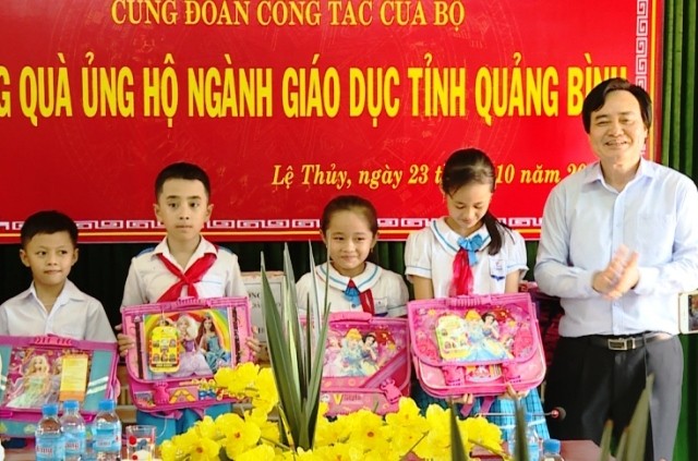 Bộ trưởng Phùng Xuân Nhạ trao quà cho học sinh vùng lũ ở Quảng Bình. (Ảnh: L.T)