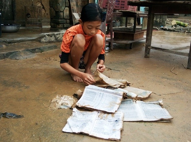 Sách vở của em Hoàng Thị Ngọc Thúy (SN 2005, trường THCS Cảnh Hóa, huyện Quảng Trạch) bị nước lũ cuốn trôi, chỉ còn sót lại một vài quyển sách đã ướt nhẹp. (Ảnh: Thủy Phan)