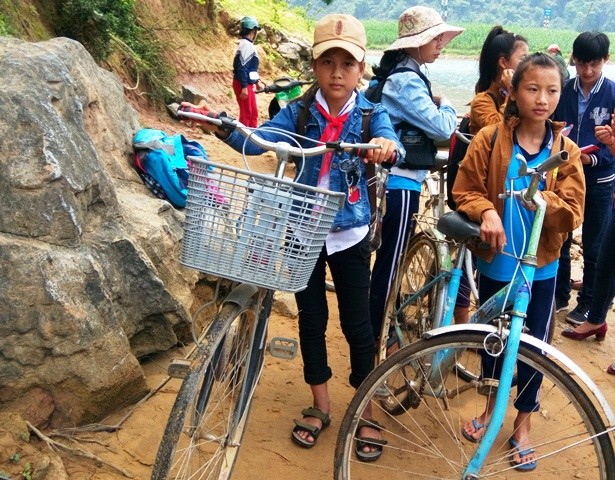 Vừa cho được cả xe lẫn người qua sông, nhiều em học sinh cấp 2 lại phải hì hục đạp xe gần 5 cây số đến trường. (Ảnh: Thủy Phan)