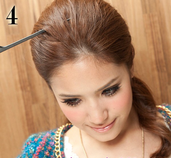 Lấy một thanh kim loại nhỏ và dài kéo dãn một phần tóc trên đỉnh đầu theo hình vòng cung để tạo độ phồng cho mái tóc.