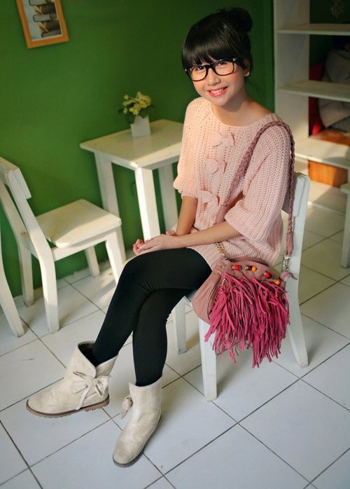 Cùng với đó, Quỳnh Anh thể hiện phong cách thời trang nhẹ nhàng và tinh tế: sắc hồng của áo len và túi xách, phối hợp ăn ý với màu đen của quần tregging, màu trắng của bốt.