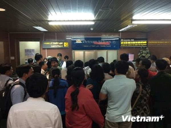 Rất đông hành khách tụ tập trước quầy bán vé để phản đổi cách xử lý tình huống của Vietnam Airlines. (Ảnh: PV/Vietnam+)