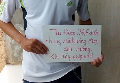 Em Trần Văn Sâm (Bình Thuận) cầm tấm biển cạnh chợ Mũi Né, cầu mong sự giúp đỡ (ảnh:Báo Pháp luật TP.HCM)