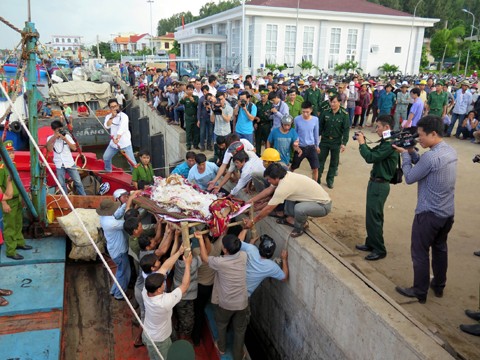 Thi thể ngư dân Trương Đình Bảy (42 tuổi) được đưa về nhà an táng (ảnh:TTXVN).