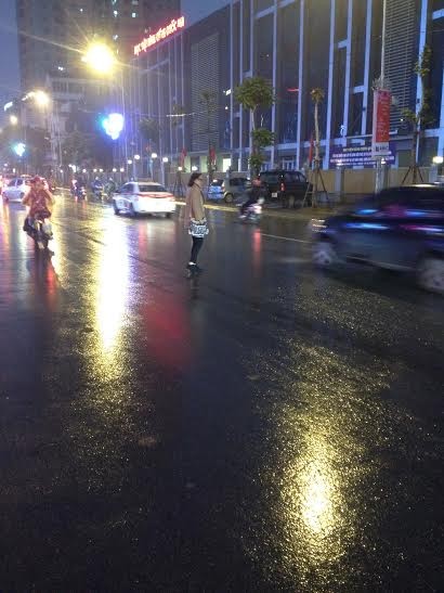 Người phụ nữ thản nhiên băng qua đường Nguyễn Chí Thanh trong khi phía trước có rất nhiều phương tiện đang di chuyển (ảnh: THỤY DU)