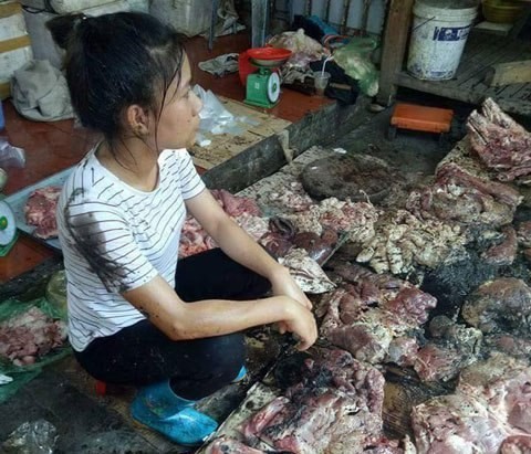 Chị Đỗ Thị Xuyến thất thần nhìn hàng thịt lợn nhuốm đầy luyn (ảnh nguồn vietnamnet.vn).