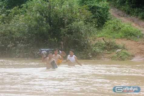 Sau khi vượt qua chặng đường hơn 3km đường rừng, các thầy, cô giáo buộc phải lội qua con suối Ngàm có chiều sâu hơn một mét, chiều rộng khoảng 60m, nước chảy xiết. Ảnh: Xuân Quang.