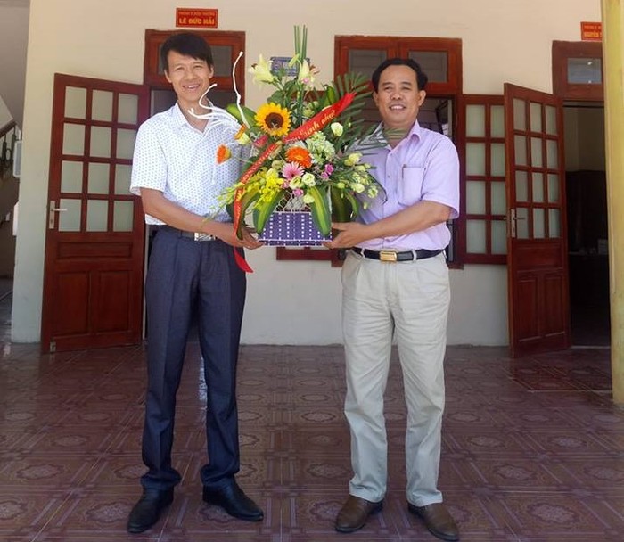 Thầy giáo Đỗ Thế Minh nhận hoa chúc mừng từ Hiệu trưởng Lê Văn Dỵ Ảnh của nhân vật cung cấp.