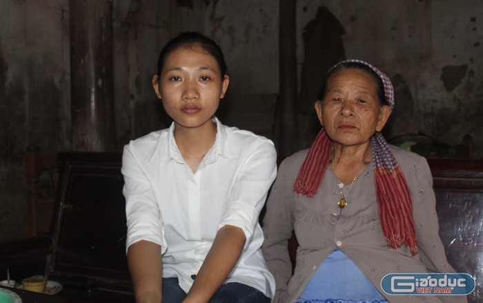Em Nguyễn Thị Hoa và bà nội bên căn nhà cấp 4 cũ kỹ tại Thôn Duệ, xã Định Tiến, huyện Yên Định. Ảnh của Thảo Nguyên.