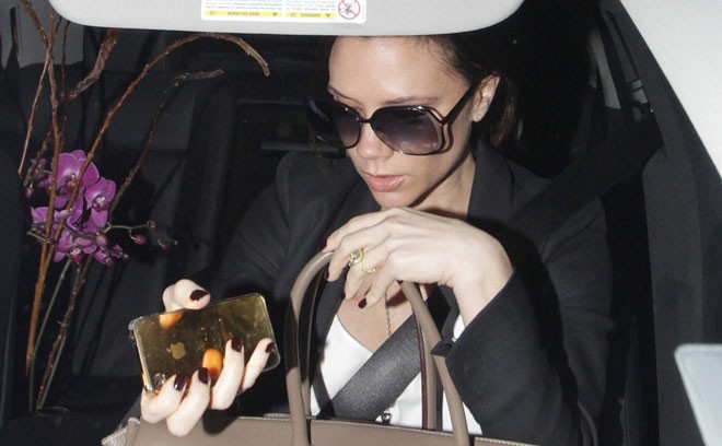 Victoria Beckham nâng niu chiếc iPhone giống như với chiếc túi xách sành điệu và những mặt hàng thời trang cao cấp.