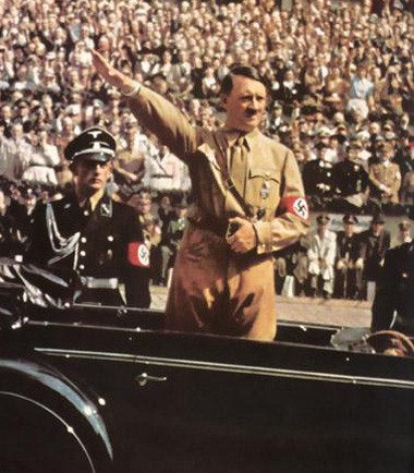 Trùm phát xít Adolf Hitler chào kiểu Nazi trong một cuộc duyệt binh.