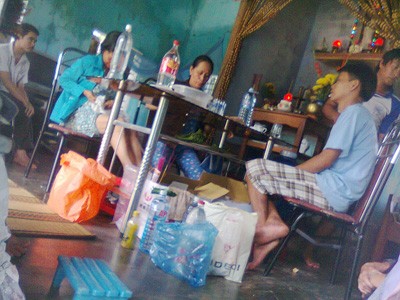 Bà Châu (ngồi giữa) đang “bốc thuốc“ cho người bệnh tại nhà. (ảnh chụp bằng điện thoại)