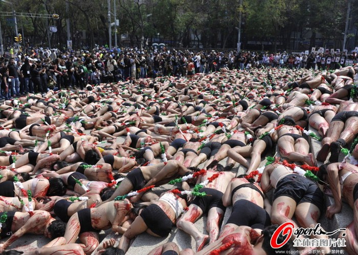 Hàng trăm thanh niên bán khỏa thân nằm giả chết, bên cạnh là đám đông hiếu kỳ và các phóng viên.
