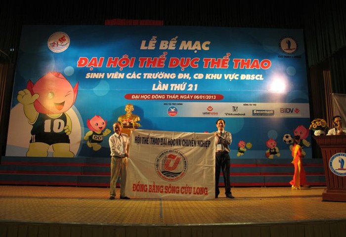 Thầy Nguyễn Văn Đệ, Hiệu trưởng ĐH Đồng Tháp, Trưởng BTC trao cờ đăng cai Đại hội TDTT sinh viên lần thứ XXII năm 2013 cho đại diện ĐH Cần Thơ.