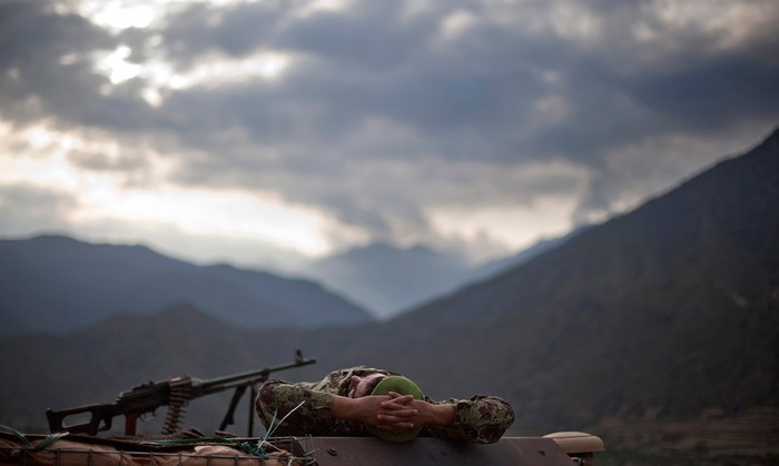Một binh sĩ Afghanistan thức giấc trên mui xe vũ trang sau một đêm làm nhiệm vụ với binh lính Mỹ ở Shigal, tỉnh Kunar.