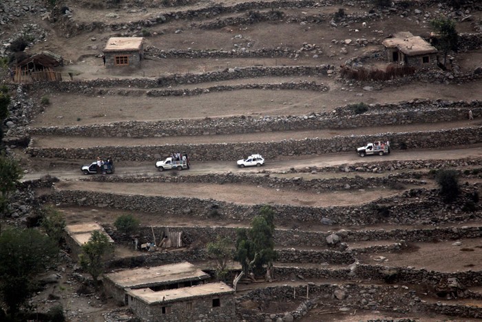 Đoàn xe đi qua một ngôi làng, với góc nhìn từ một boongke ở tiền đồn Bari Alai, Kunar.
