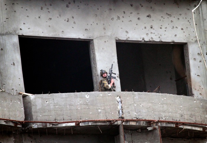 Một binh sĩ thuộc lực lượng liên quân ngừng bắn trong cuộc đấu súng với phiến quân Taliban trong một tòa nhà ở Kabul, 14/09/2011.