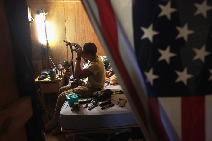 Binh nhất Natan Martinez lau súng trong căn phòng của anh ở đài quan sát Mustang, Afghanistan.