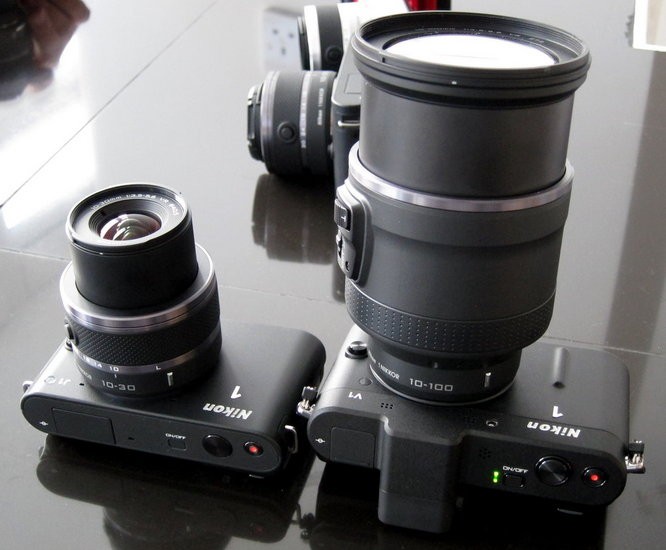 Nikon J1 và V1 Nikon quyết định những chiếc máy ảnh không gương lật của họ phải có tốc độ nhanh hơn của các hãng khác. Và kết quả là hai chiếc máy J1 và V1 trang bị cảm biến ảnh 10,1-megapixel có thể chụp với 73 điểm bắt nét nhanh và khả năng quay phim HD 1080p. J1 và V1 khác nhau ở điểm J1 có đèn flash nhưng không có ống ngắm điện tử còn V1 thì có ống ngắm điện tử và cổng cắm thêm thiết bị phụ nhưng lại không có flash. Giá: J1 - 13,5 triệu đồng (650 USD); V1 - 18,7 triệu đồng (900 USD)