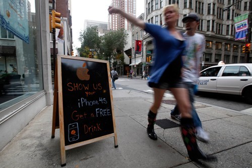 Ở Philadelphia, quán ING Direct Cafe treo biển sẵn sàng phục vụ đồ uống miễn phí nếu khách đến có mang theo iPhone 4S (Ảnh: AP)