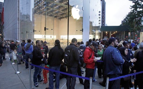 Ngay trước cửa gian hàng trưng bày của Apple tại New York, khách hàng đến từ đêm hôm trước đã có thể nhìn thấy những chiếc iPhone 4S sau cửa kính. Nhưng họ sẽ phải xếp hàng chờ đến giờ mở cửa. (Ảnh: AP).