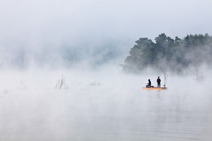 FISHING ON THE CLOUD: Hai người ngồi câu cá trong làn sương mờ bốc lên từ mặt hồ lúc bình minh trong như đang câu cá trên mây. Ảnh chụp bởi Sungjin Kim, tại hồ Gosam, Anseong, Gyeonggi-do, Hàn Quốc.