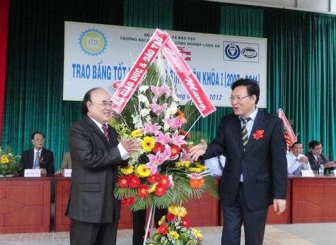 Bộ trưởng Bộ GD&ĐT - Phạm Vũ Luận, tặng hoa tại lễ tốt nghiệp