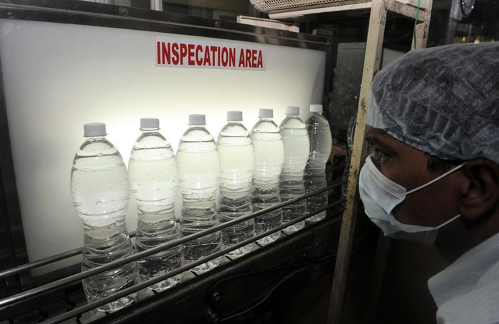 11. Một kỹ thuật viên người Ấn Độ đang theo dõi dây chuyền sản xuất tại bộ phận kiểm tra chất lượng của nhà máy nước khoáng thiên nhiên Aava ở Ahmedabad, Ấn Độ ( 20/3/2012). Đây là một trong những nhà máy sản xuất nước khoáng đóng chai lớn nhất Ấn Độ với sản lượng hơn 1500.000 chai/ngày.