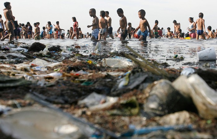 26. Nhiều người phải lội qua vịnh Manila với toàn rác thải tại Manila, Philippines ( 24/4/2011).