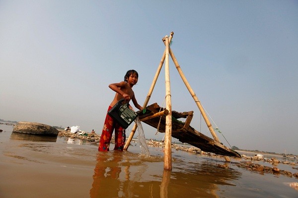 Cô bé gái này đang đãi vàng tại con sông Irrawaddy, Myanmar. Công việc này đem lại cho cô thu nhập từ 3 - 12 USD (khoảng 60 - 240.000 VNĐ) mỗi ngày. (Ảnh: Soe Zeya Tun).