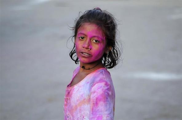 Bé Sita, 12 tuổi, với khuôn mặt đầy bột màu trong lễ hội Holi hay còn được gọi là lễ hội của màu sắc.