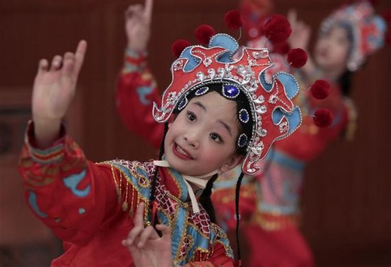 Một bé gái đang tập điệu múa truyền thống Trung Quốc trước một buổi biểu diễn chào mừng ngày Quốc tế Phụ nữ tại Đại lễ đường Nhân dân ở Bắc Kinh.