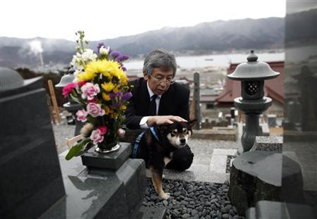 Ông Koyu Morishita, 54 tuổi im lặng trước ngôi mộ của cha mình, người đã thiệt mạng trong trận động đất, sóng thần năm ngoái.