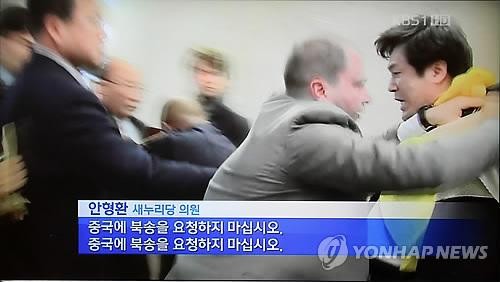 Nghị sĩ Ahn Hyoung-hwan của đảng cầm quyền Hàn Quốc bị chặn bởi các nhân viên an ninh khi ông cố gắng đến gần nhà ngoại giao Triều Tiên.
