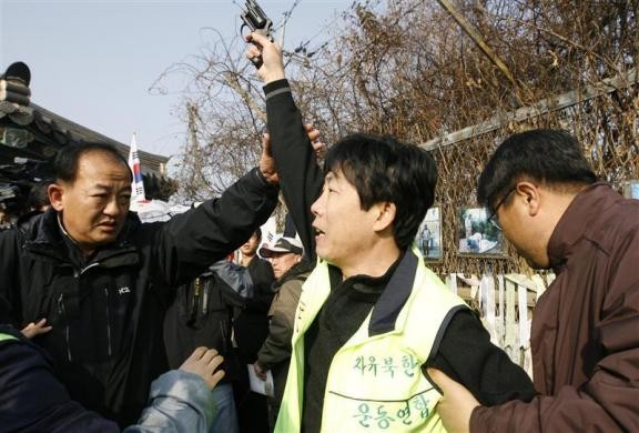 Cảnh sát cố gắng ngăn chặn Park Sang-hak - một người Triều Tiên từng đào tẩu đang bắn súng hơi cay ở Imjinkak gần khu phi quân sự.