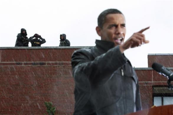 Ứng cử viên tổng thống của Đảng Dân chủ -Barack Obama phát biểu trong cơn mưa tầm tã. Các nhân viên mật vụ đang đứng trên một mái nhà gần đó trong một mít tinh lớn tại Đại học Widener ở Chester, Pennsylvania.