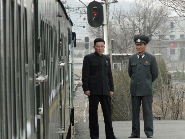 Quan chức Triều Tiên đứng ở bến ga để đảm bảo sự an toàn cho các phóng viên lên tàu trong chuyến đi đến bãi thử Tongchang-ri.