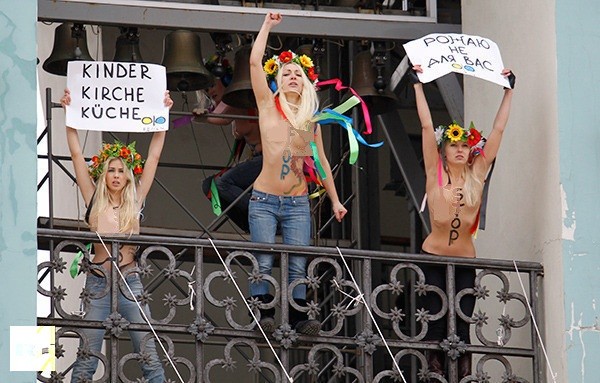 Thành viên FEMEN đứng ngoài ban công nhà thờ và hô to.