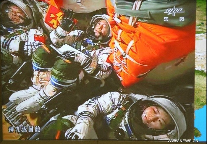 Màn hình tại Trung tâm kiểm soát Không gian vũ trụ Bắc Kinh quay lại hình ảnh các nhà du hành Trung Quốc Jing Haipeng, Liu Wang và Liu Yang sau khi khởi động tàu vũ trụ Thần Châu 9.
