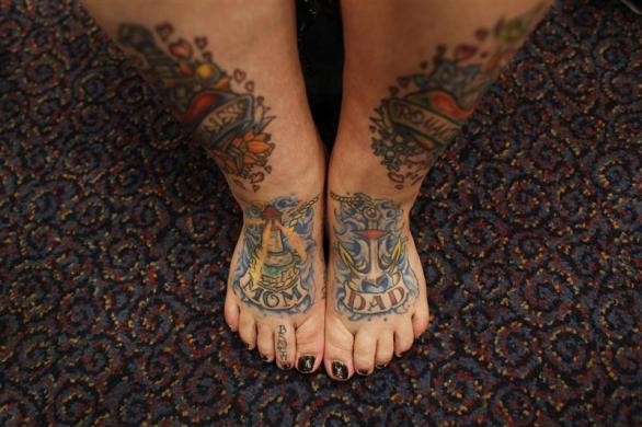 Keisha Holcomb, 31 tuổi, đến từ Fort Collins, Colorado đang khoe những hình xăm ở chân. Holcomb khi mới 16 tuổi đã bắt đầu xăm hình và bây giờ cô mới trở thành một nghệ sĩ xăm hình. Cô muốn xăm hình toàn thân nhưng ngoại trừ cổ họng, bàn tay và đầu.