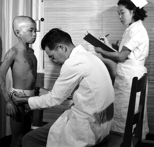 Bác sỹ nhi khoa đang khám bệnh cho cậu bé vào năm 1949 - một trong những nạn nhân của thảm hoạ ném bom nguyên tử.