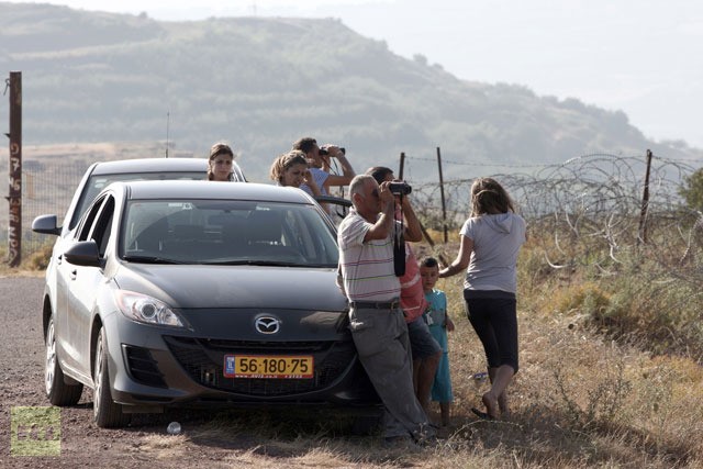 Một gia đình đang dùng ống nhòm để quan sát tình hình Syria ở bên kia biên giới.