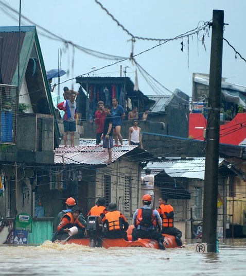 Lực lượng cứu hộ đến cứu những người phải đứng trên mái nhà.