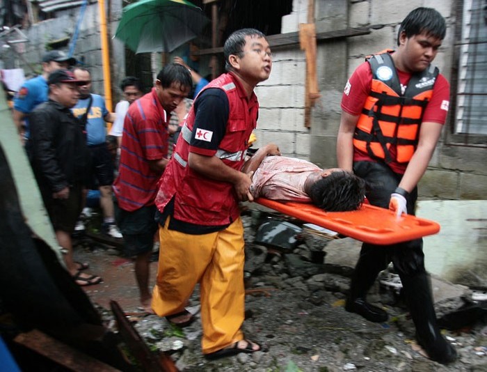 Lực lượng cứu hộ đưa một nạn nhân vụ lở đất ra ngoài sau khi kéo anh ra khỏi đống đổ nát.