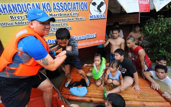 Lực lượng cứu hộ sơ tán trẻ em ra khỏi những ngôi nhà bị ngập lụt ở Marikina.