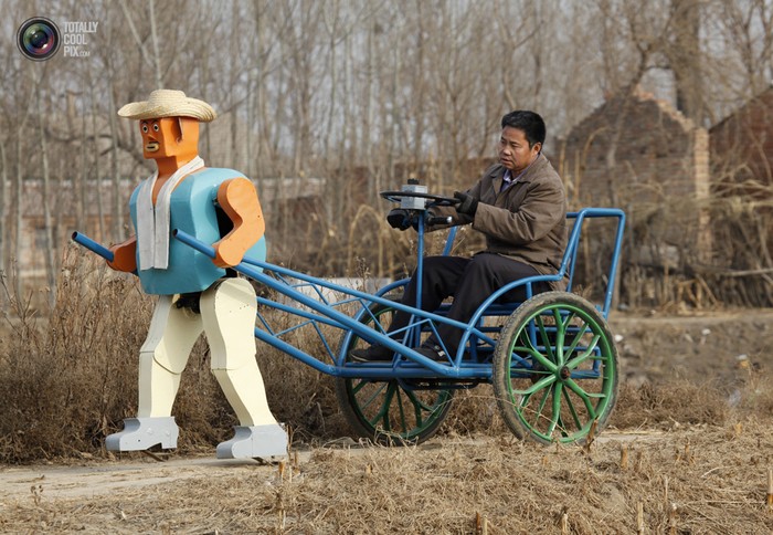 Ngô Ngọc Lộc với chiếc xe kéo được 1 con robot kéo đi ở một ngôi làng ngoại ô Bắc Kinh. Đây là phát minh mới nhất và lớn nhất của ông Lộc, người bắt đầu tạo ra robot từ năm 1986 bằng các vật liệu phế thải lấy về từ bãi rác.