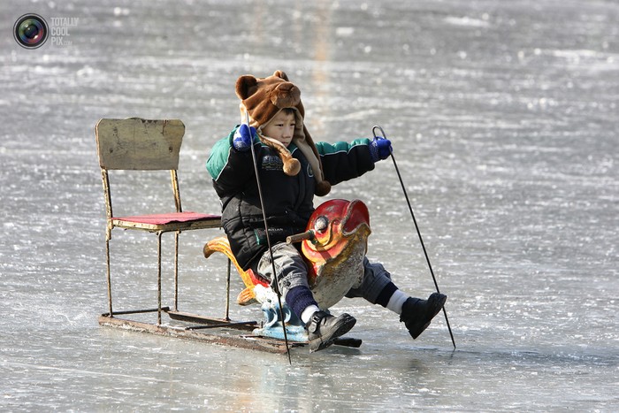Một đứa trẻ cưỡi một chiếc ghế trượt băng đặc biệt ở hồ Hậu Hải, Bắc Kinh.